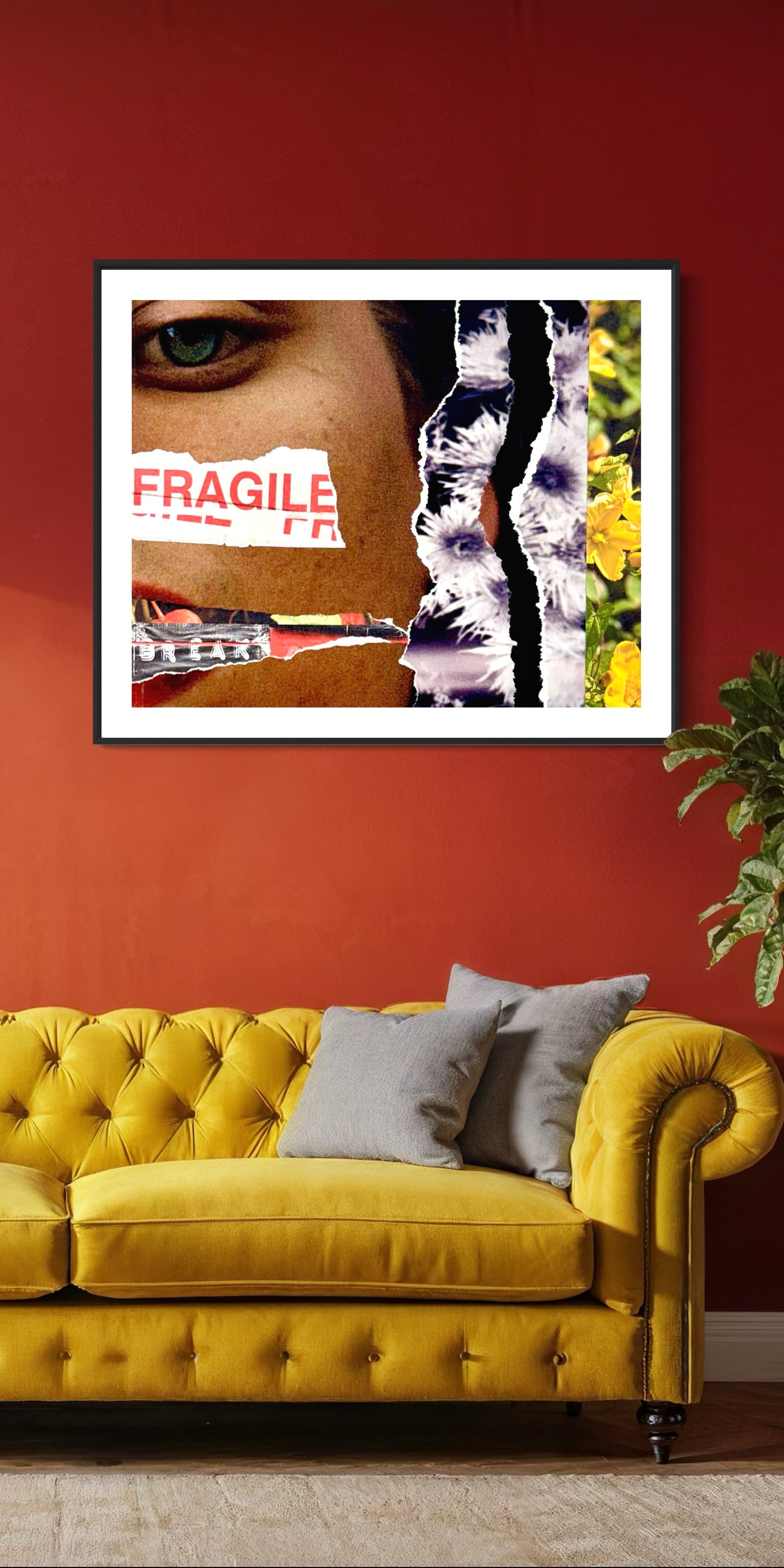 Framed artwork on a red wall above a yellow sofa with gray cushions.
