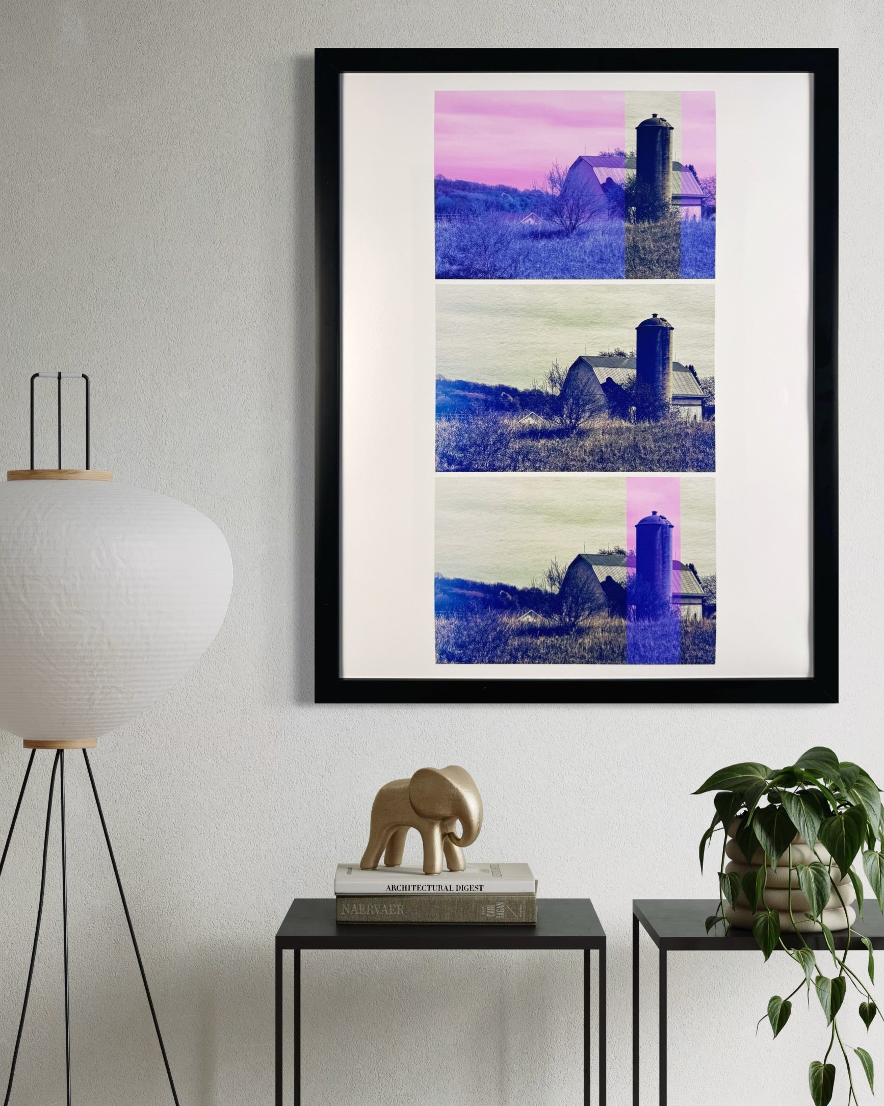Framed artwork of a barn and silo on a white wall with decorative elements below.